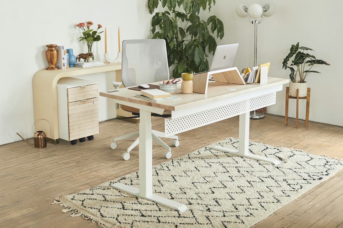 Escritorio elevable blanco en un despacho (imagen ilustrativa)